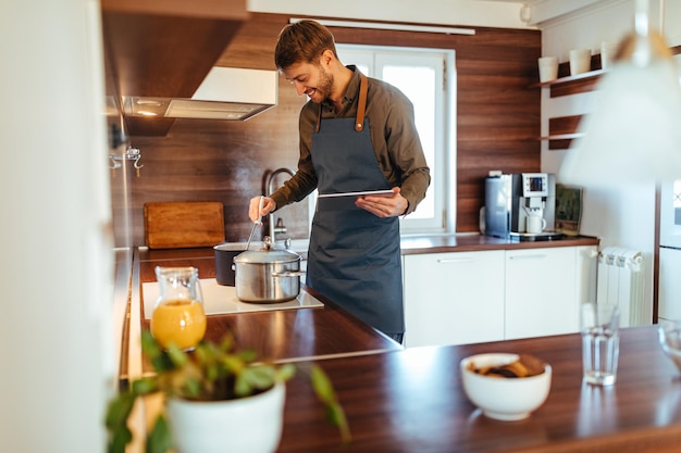 Handsome male cooking in his kitchen