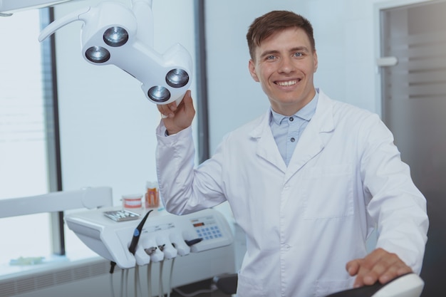 Handsome male dentist working at his clinic