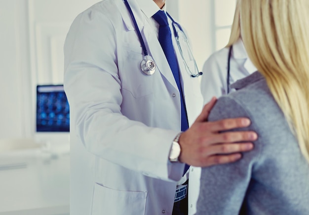 Handsome male doctor consulting a couple about infertility in his medical office