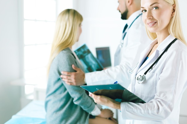 Handsome male doctor consulting a couple about infertility in his medical office