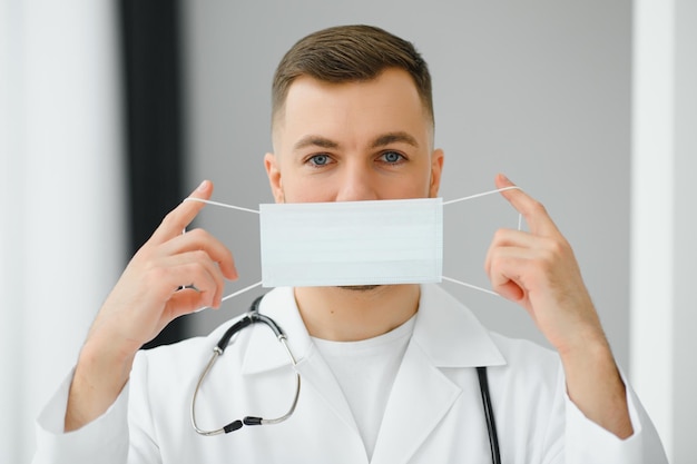 Handsome male doctor in medical uniform put on protective mask against covid19 virus Coronavirus protection healthcare medical equipment