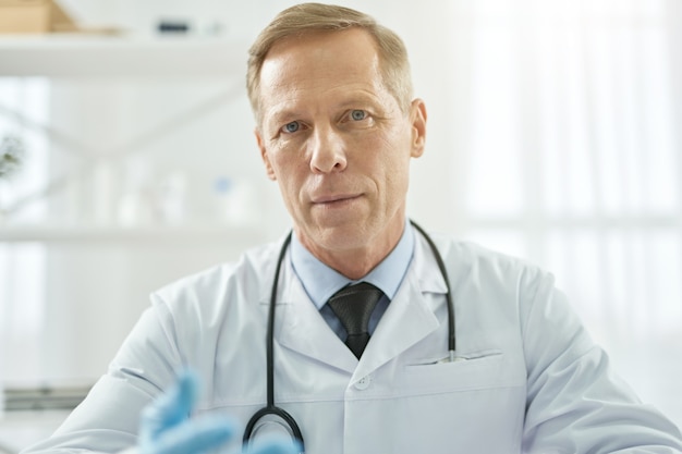 Handsome male doctor posing against white background