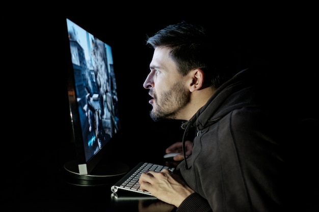 Handsome male gamer playing computer video game