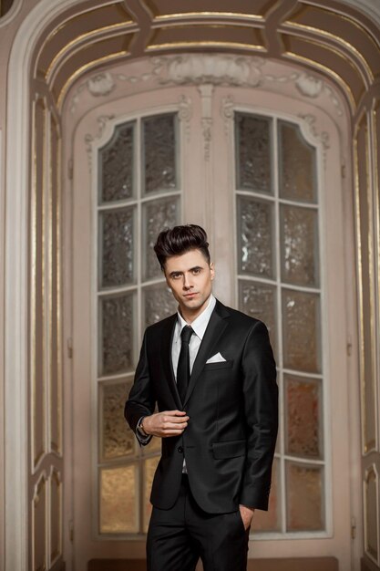 Handsome male model in a new suit in a beautiful room