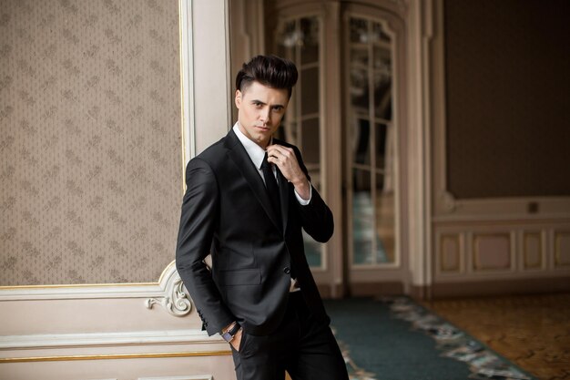 Handsome male model in a new suit in a beautiful room