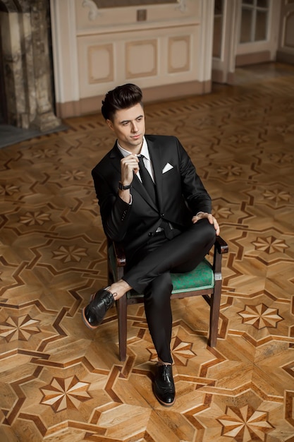 Handsome male model in a new suit in a beautiful room