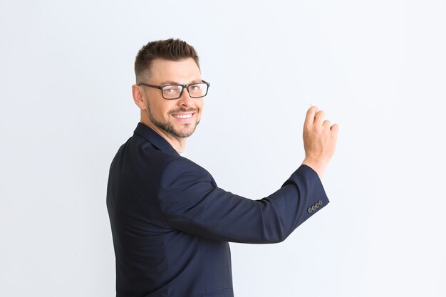 Handsome male teacher writing something on white