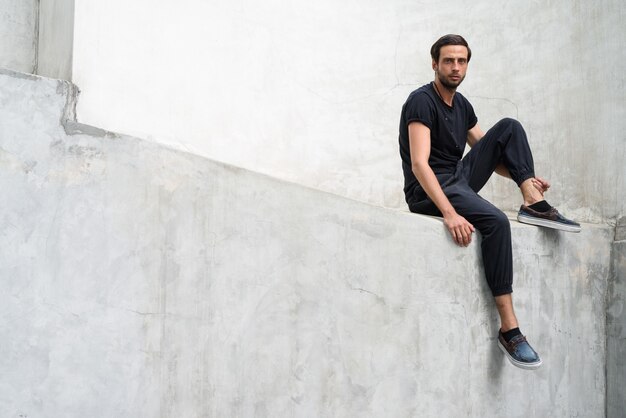 Handsome man against concrete wall in the streets outdoors