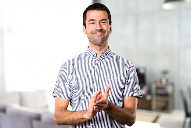 Handsome man applauding inside house