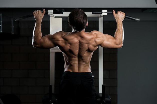 Handsome Man Athlete Doing Pull Ups  ChinUps In The Gym