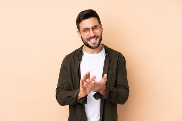 Handsome man on beige applauding after presentation in a conference