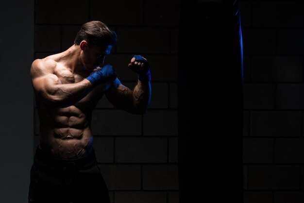 Handsome Man In Blue Boxing Gloves  Boxing In Gym  The Concept Of A Healthy Lifestyle  The Idea For The Film About Boxing