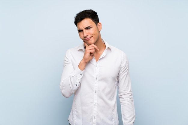 Handsome man over blue wall Looking front