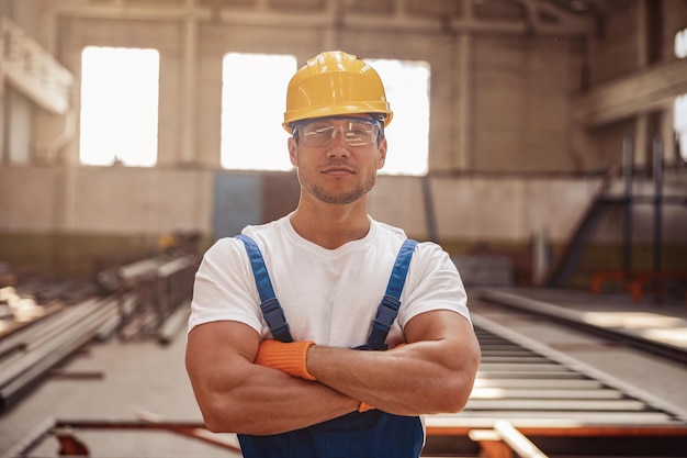 Handsome man builder standing inside building under construction