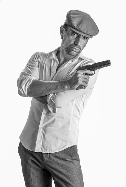 Uomo bello in berretto con una pistola