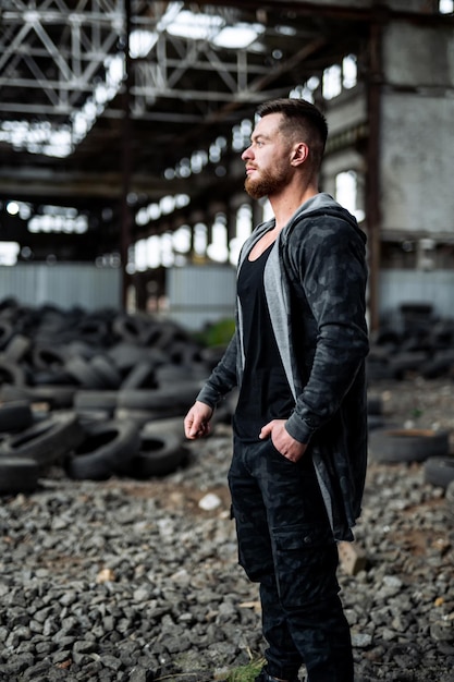 Handsome man in casual cloth on ruined building Serious young guy in abandoned building