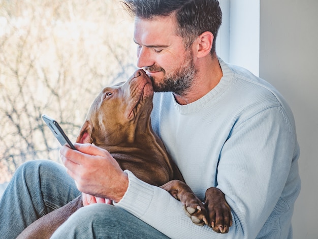 ハンサムな男と魅力的な子犬。閉じる