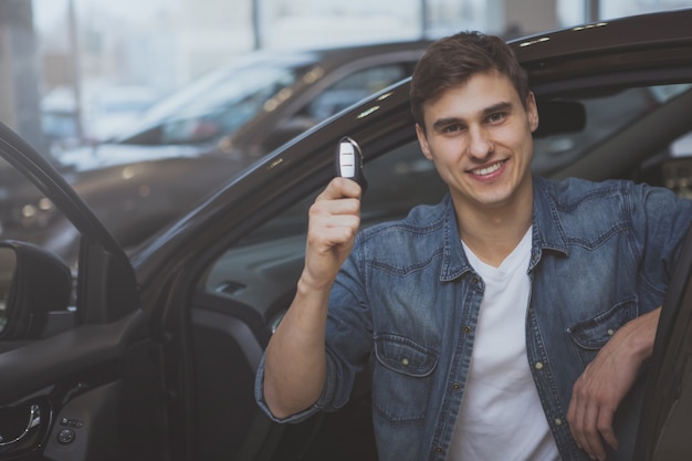 Handsome man choosing new automobile to buy