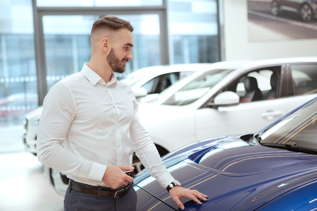handsome man choosing new automobile at the dealership