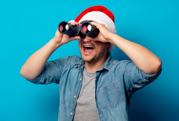 Handsome man in Christmas hat with binoculars