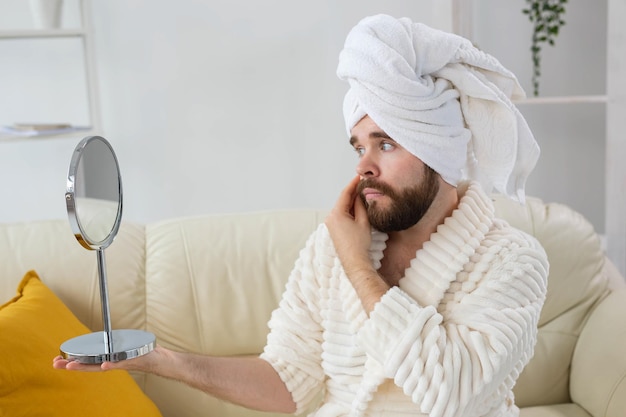 Uomo bello che pulisce la pelle del viso con tamponi di cotone. spa, cura del corpo e della pelle per il concetto maschile.