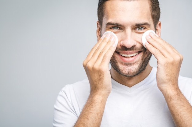 handsome man cleansing his skin with cotton pads