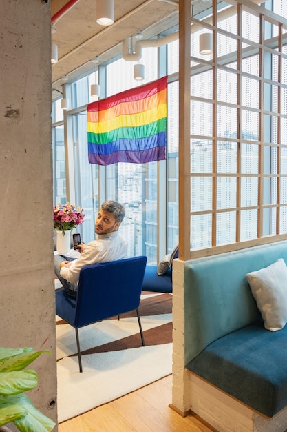 Foto uomo bello che contempla la bandiera che rappresenta la comunità lgbt