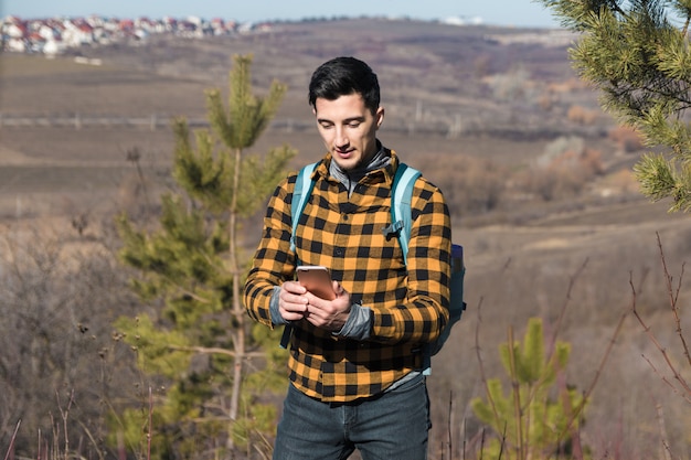 handsome man in countryside using phone to navigate