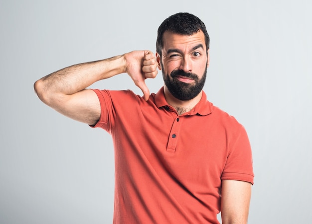 Handsome man doing bad signal