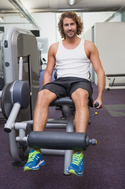 Handsome man doing leg workout at gym