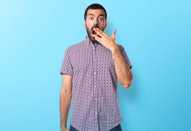 Handsome man doing surprise gesture on colorful background