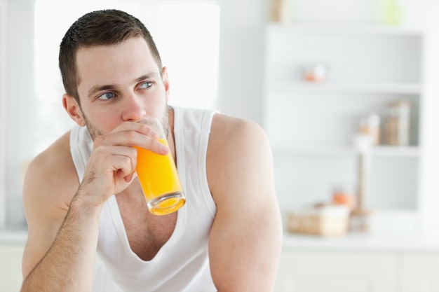 オレンジジュースを飲むハンサムな男