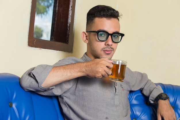 Handsome man drinking a tea in his room