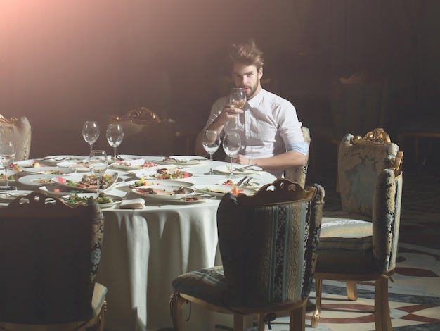 Handsome man drinks wine