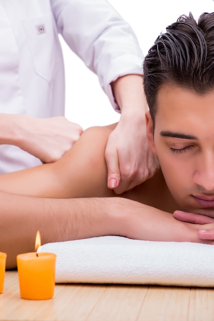 Uomo bello durante la sessione di massaggio spa