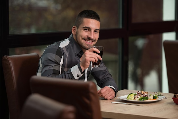 Handsome Man Eating At A Restaurant And Looking Happy