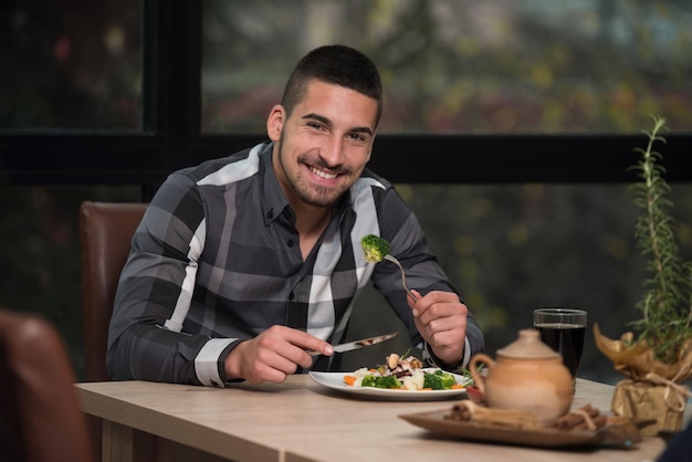 Handsome Man Eating At A Restaurant And Looking Happy