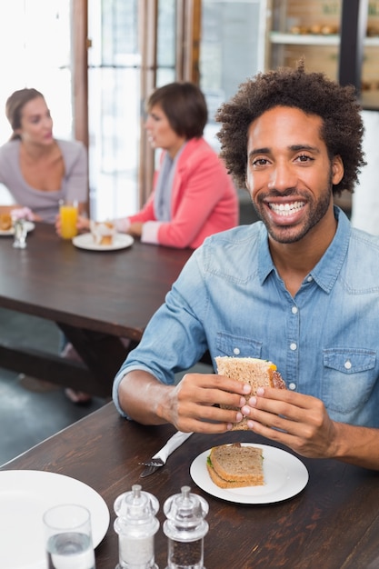 Handsome man eating a sandwich