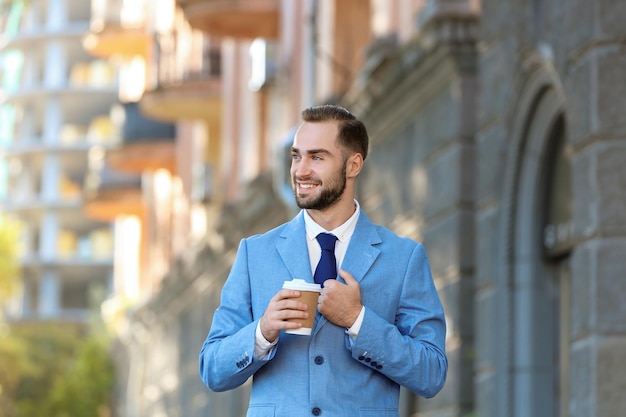 Handsome man in elegant suit outdoors