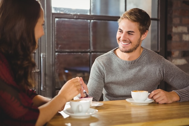 友人とケーキとコーヒーを楽しむハンサムな男