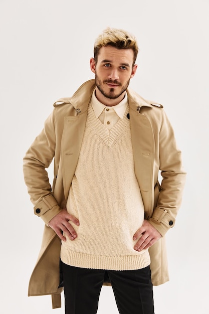 Handsome man fashion hairstyle beige coat studio cropped view light background High quality photo