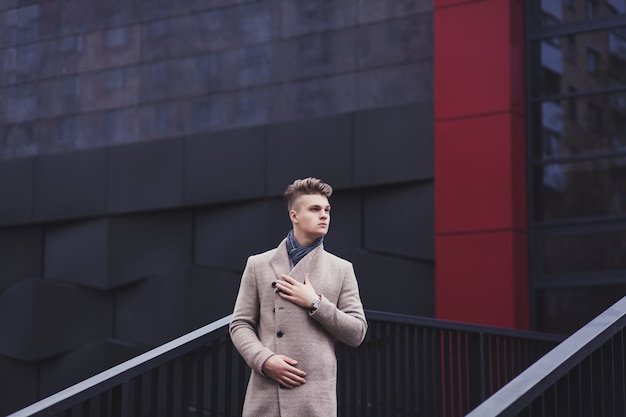 Handsome man in fashionable clothes standing on an urban street