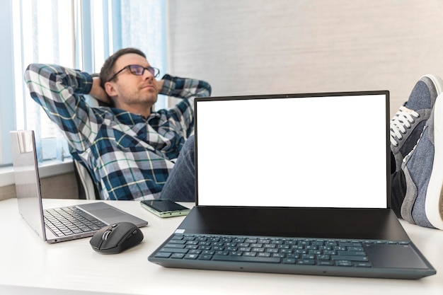멋진 남자가 지루하고 좌절하고 졸리고 지루한 사업가와 책상 개념 빈  ⁇  노트북 화면에 복사 공간 행복한 프리랜서가 사무실에서 일하고 싶지 않습니다
