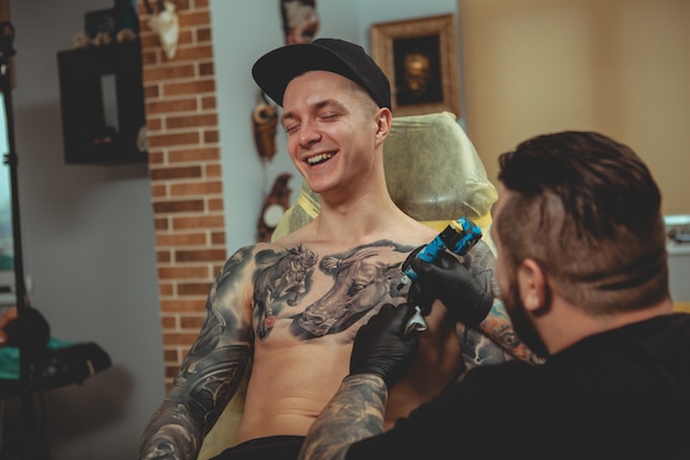 Фото Красивый мужчина получает татуировку в студии альтернативного искусства