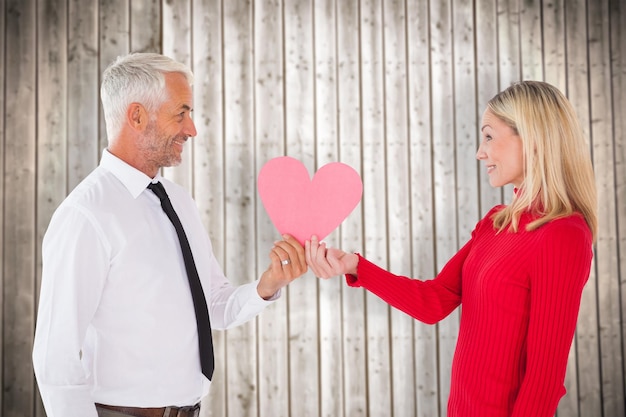 Foto bell'uomo che ottiene una moglie a forma di carta di cuore su sfondo di assi di legno