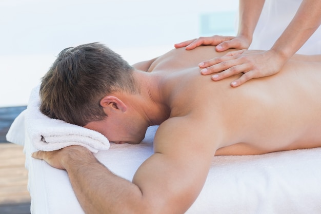 Handsome man getting a massage poolside