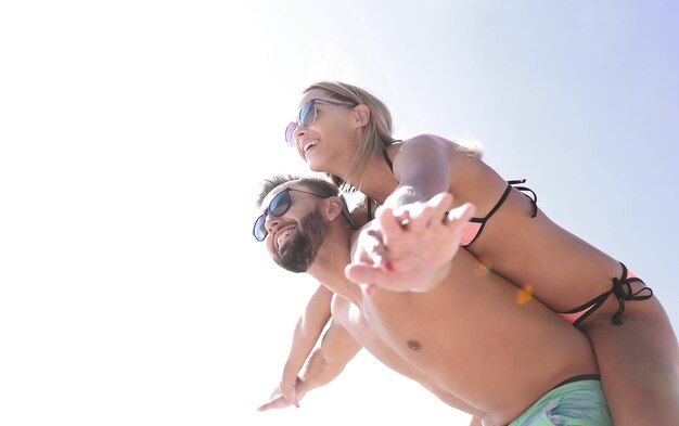 Handsome man giving piggy back to his girlfriend