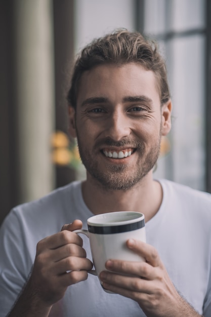 Handsome man having a cup of hot coffee