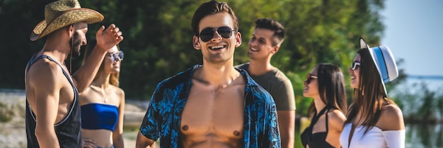 Foto il bell'uomo che si diverte con i suoi amici in spiaggia