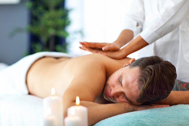 handsome man having massage in spa salon